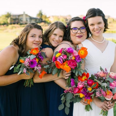Bride and bridesmaids holding bouquets together.